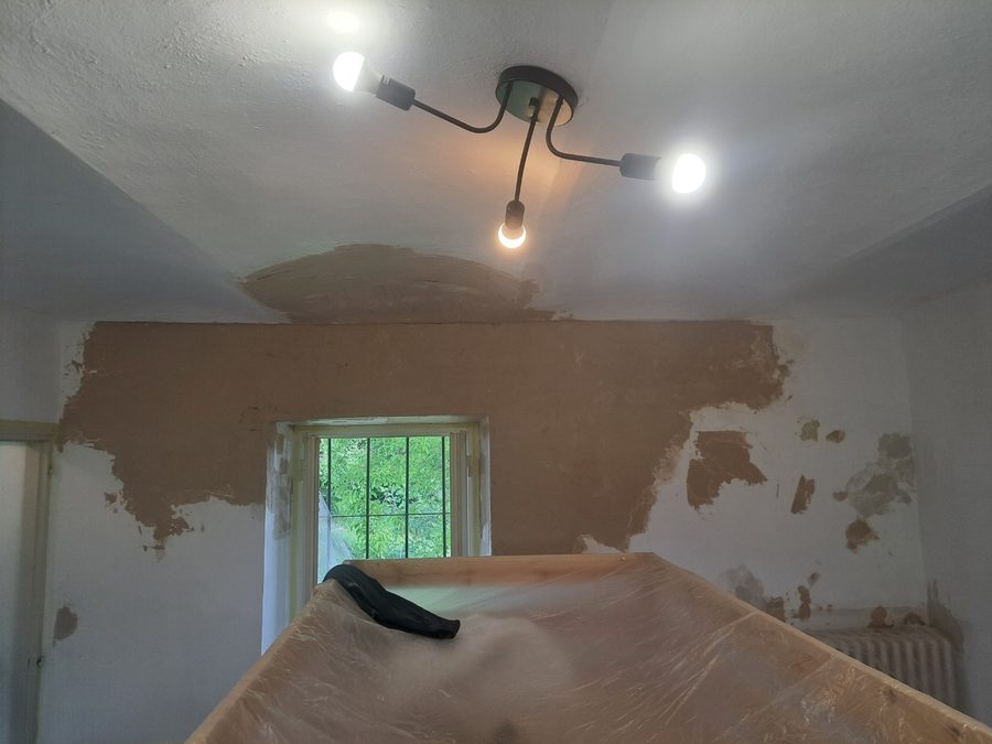 Lampadario a tre luci montato e pareti stuccate prima della tinteggiatura